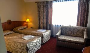 una habitación de hotel con 2 camas y una silla en Falborek Noclegi, en Brześć Kujawski