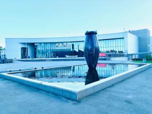 a vase sitting in a fountain in front of a building at Husnes Sentrum Hotell in Husnes