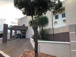a palm tree in front of a building at Nioja Hotel in Itumbiara