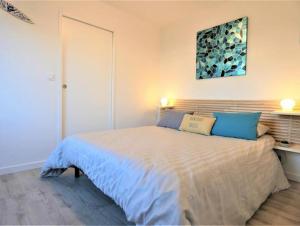 a bedroom with a large bed with blue pillows at Villa Uhaïna Hossegor in Hossegor