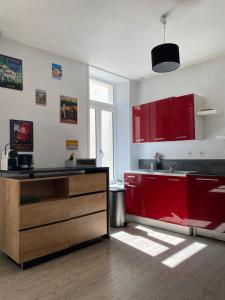 a kitchen with red cabinets and a sink at Appartement au coeur de la vieille ville in Boulogne-sur-Mer