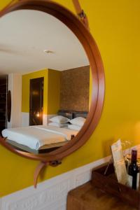 a large mirror in a bedroom with a bed at Hotel V Nesplein in Amsterdam