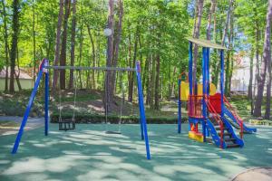 a playground with a colorful swing set in a park at Apartamenty Świnoujście - Wyspiańskiego 34e in Świnoujście