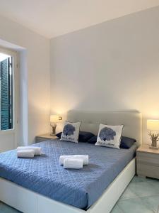 - une chambre blanche avec un lit bleu et 2 oreillers dans l'établissement Peace Nest Forte dei Marmi, à Forte dei Marmi