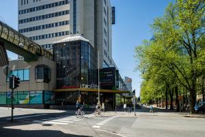 two people riding bikes down a street in a city at Omena Hotel Vaasa Espen in Vaasa