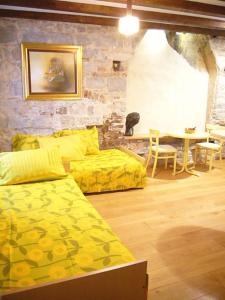 a living room with yellow beds and a table at Split Old Town Apartments in Split