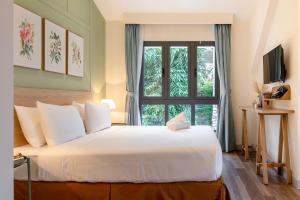 a bedroom with a large white bed with a window at La Em Boutique Villa in Da Lat