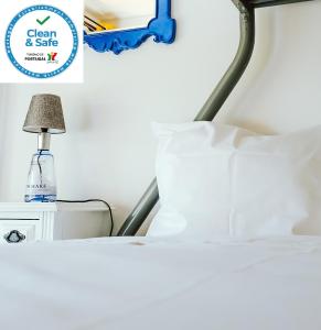 um quarto com uma cama e um candeeiro numa mesa de cabeceira em Help Yourself Hostels - Restelo em Lisboa