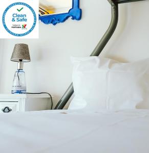 sypialnia z łóżkiem i lampką na szafce nocnej w obiekcie Help Yourself Hostels - Restelo w Lizbonie