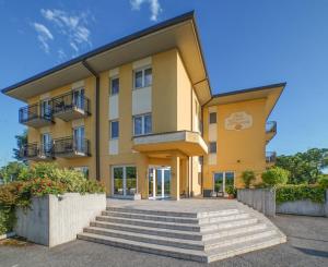 a yellow building with stairs in front of it at Hotel Nuova Barcaccia in Peschiera del Garda