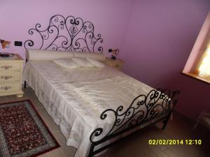 um quarto com uma cama branca e uma cabeceira de metal em Le Cocche em Affi