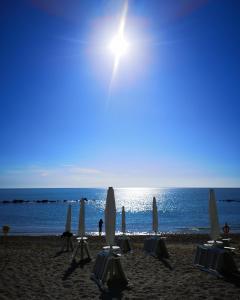 a group of umbrellas and chairs on a beach at Appartamento al mare con garage in Porto Recanati