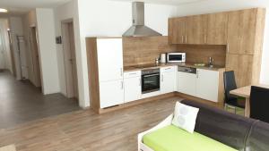 ウムハウゼンにあるStockers Apartの白いキャビネットとソファ付きのキッチンが備わります。