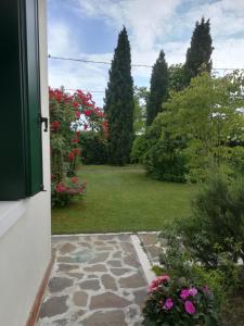 an open door to a garden with flowers and trees at Casa Pianta in Cavallino-Treporti