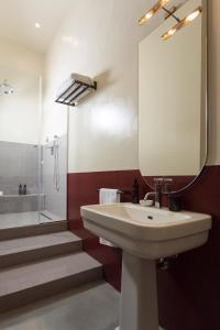 y baño con lavabo, espejo y ducha. en Palazzo Colombo, en Gallipoli