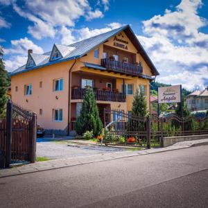 a building with a fence in front of it at Pensiunea Angela in Vatra Dornei +83 photos