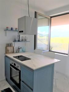 a kitchen with a sink and a counter with chairs at Duplex Seaview Condo in Durrës