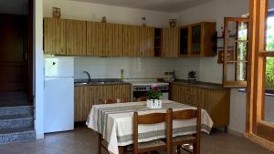 uma cozinha com uma mesa e um frigorífico branco em Casa Tita em Amaroni
