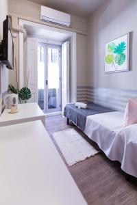 een slaapkamer met 2 bedden en een raam bij El Hostall in Madrid