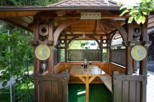 a wooden gazebo with a table in it at Hostel LakeBled in Bled