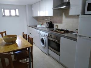 uma cozinha com uma máquina de lavar roupa e uma mesa em Harmonia em Ouzenda
