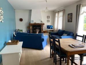 a living room with a blue couch and a table at Maison Nathalie Mimizan in Mimizan