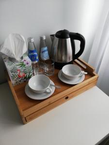 a wooden table topped with cups and plates of food at 7th Room Guest House in Oświęcim