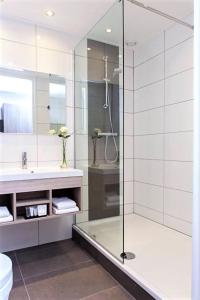 a bathroom with a shower, sink, and toilet at Hotel Asteria in Venray