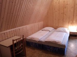 マラー・モラーヴカにあるPenzion Chata Sedmikráskaのベッドルーム1室(ベッド1台、椅子、窓付)