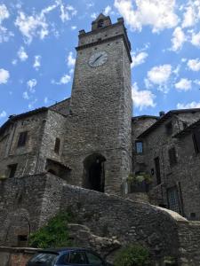 un gran edificio de piedra con una torre de reloj. en Casa Nonna Velia, en Portaria