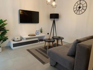 a living room with a couch and a flat screen tv at Apartments & Room Piutti in Bale
