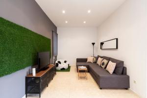 sala de estar con sofá y pared verde en The Camp Nou FCB Apartment en Barcelona
