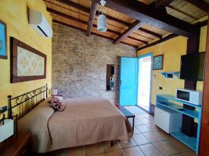 a bedroom with a bed and a tv in a room at Sa Corti De Sa Perda Piscinas in Piscinas