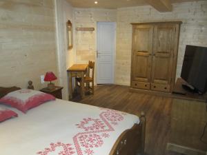a bedroom with a bed and a flat screen tv at Hôtel Chalet Le Caribou in Les Saisies