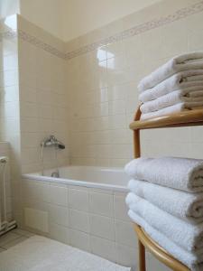 uma casa de banho com banheira e uma pilha de toalhas em Family Apartment Písek City Centre II. em Písek