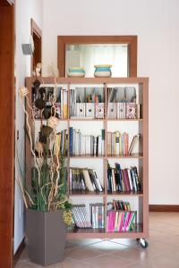 a book shelf filled with books and a potted plant at BrentaGiardino in Noventa Padovana