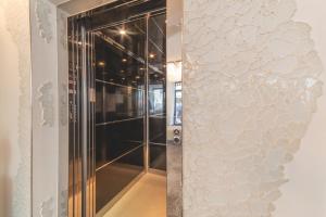 eine Glastür, die zu einer ebenerdigen Dusche führt in der Unterkunft Hotel Leon D'oro in Cattolica