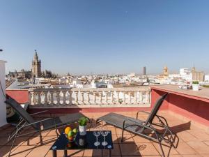 eine Terrasse mit 2 Stühlen und einem Tisch auf dem Balkon in der Unterkunft Federico rubio in Sevilla