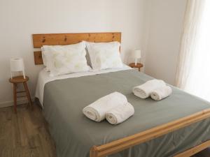 a bedroom with a bed with towels on it at Casa Boa Onda in Sagres