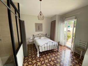 a bedroom with a bed and a glass door at Le Mazet du Petit Chemin in Caux