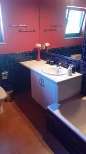 uma casa de banho com um lavatório branco e uma parede vermelha em Vistas al Sueve em Colunga