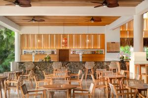 a restaurant with wooden tables and chairs at Impressive Punta Cana - All Inclusive in Punta Cana