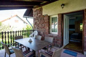a patio with a table and chairs on a porch at Zefír Apartments in Balatonfüred