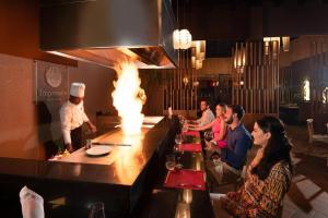 a group of people sitting at a bar in a restaurant at Impressive Punta Cana - All Inclusive in Punta Cana