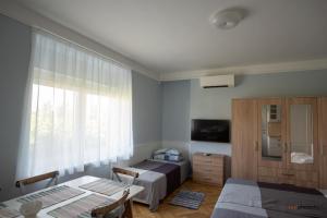 a bedroom with a bed and a table and a window at Zefír Apartments in Balatonfüred