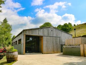 a large wooden building with a large glass door at Ash Bank, Jacobs Wood in Keighley