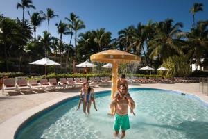 a family in a swimming pool at a resort at Impressive Punta Cana - All Inclusive in Punta Cana