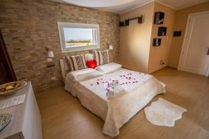 um quarto com uma cama com um coração vermelho em Vista Mare Apartments em Giardini Naxos
