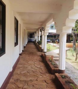 un couloir vide d'un bâtiment avec colonnes dans l'établissement Mama Pierina Restaurant and Annex, à Morogoro