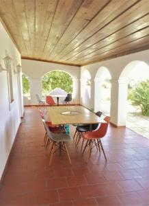 a dining room with a wooden ceiling and a table and chairs at Portela Guesthouse in Cercal